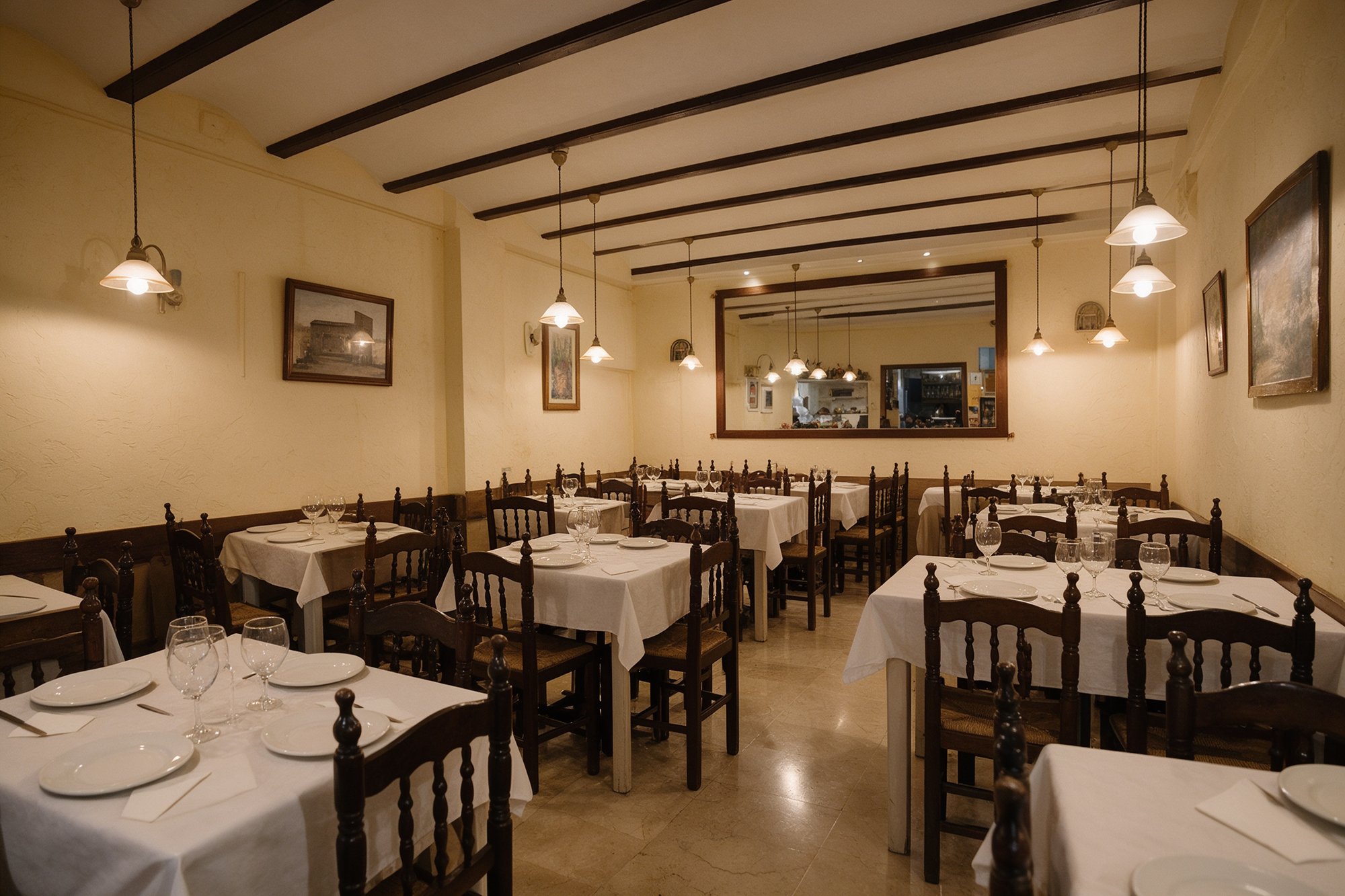 Comedor tradicional espacioso y acogedor con paredes crema, vigas de madera, mesas puestas y lámparas cálidas